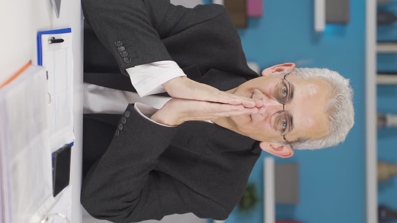 홈 오피스 직원 남자가 카메라에서 좋은 소식을 듣는 수직 비디오.