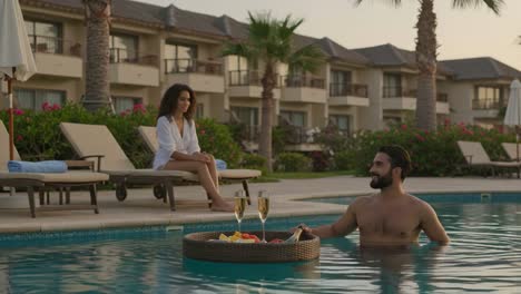relaxing poolside escape: a serene evening with refreshing drinks and lush surroundings by the water, perfect for enjoying good company and beautiful views