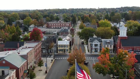 patriotic american flag waves over small town in usa