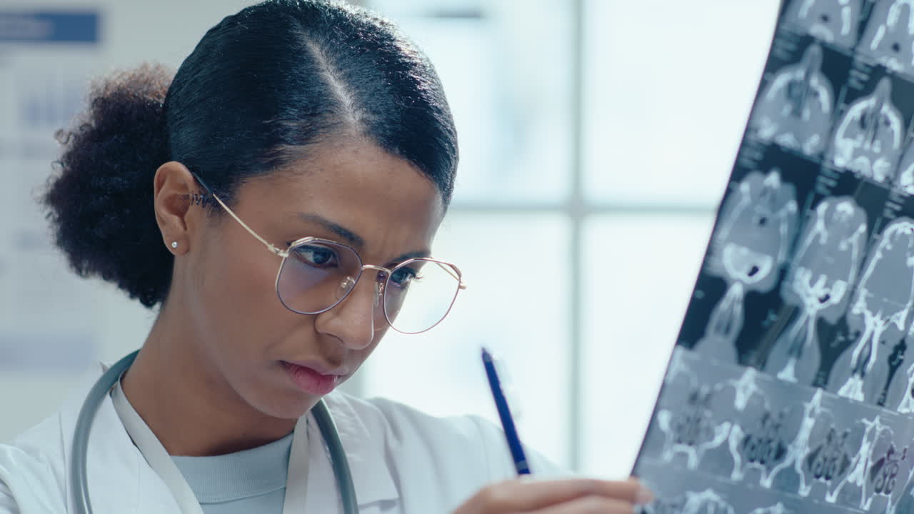 Dottoressa afroamericana che esamina un'immagine di risonanza magnetica cerebrale in clinica