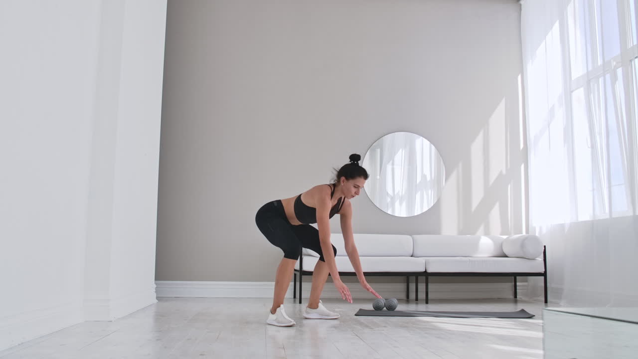 mujer de fitness haciendo ejercicio de burpee en casa. toma media de mujer joven haciendo flexiones y ejercicios de salto en cámara lenta. concepto deportivo