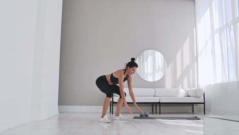 Fitness-woman-doing-burpee-workout-at-home.-Medium-shot-of-young-woman-doing-push-ups-and-jump-exercise-in-slow-motion.-Sport-concept