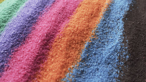 video of close up of multi coloured sand grains and copy space background