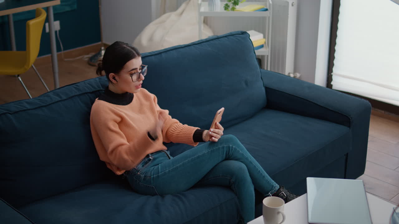 Young adult using smartphone to chat on remote video call