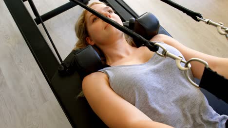 woman doing exercise with resistance bands on rowing machine 4k