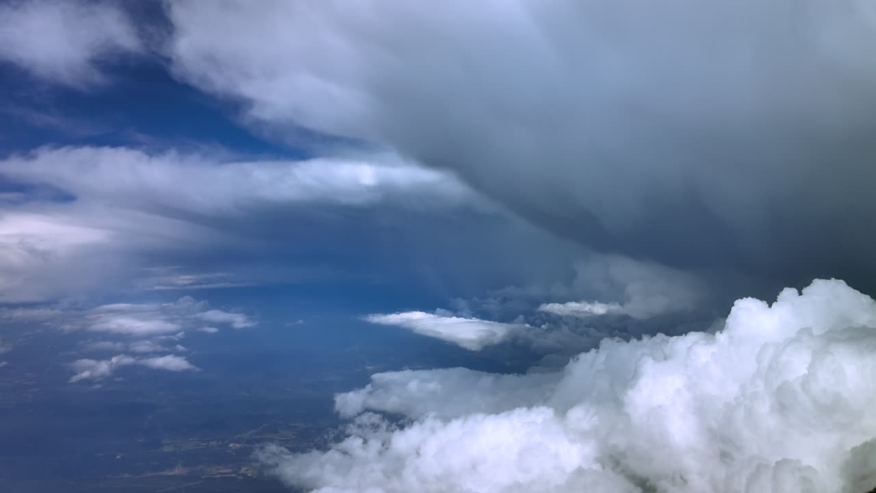 An immersive aerial view through the pilot’s eyes recorded from inside a jet cockpit flying at high-altitude near a massive cumulonimbus storm cloud. 4K