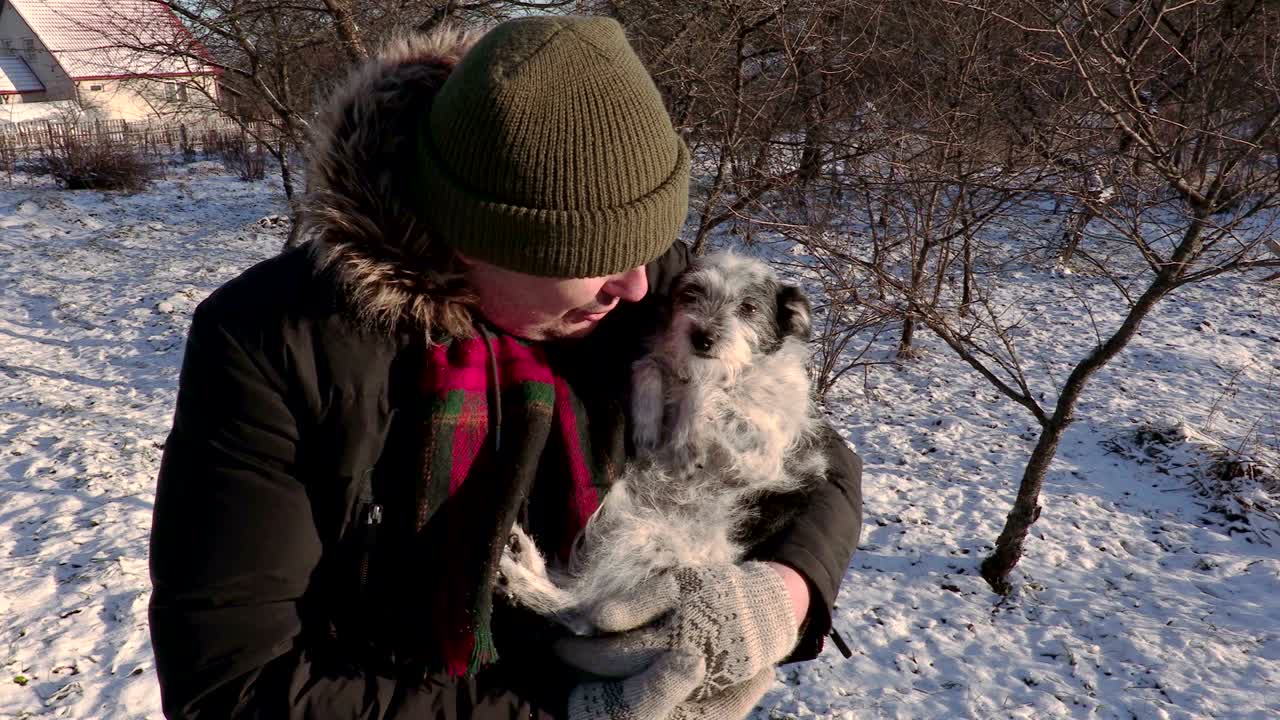 작은 개 를 들고 있는 사람