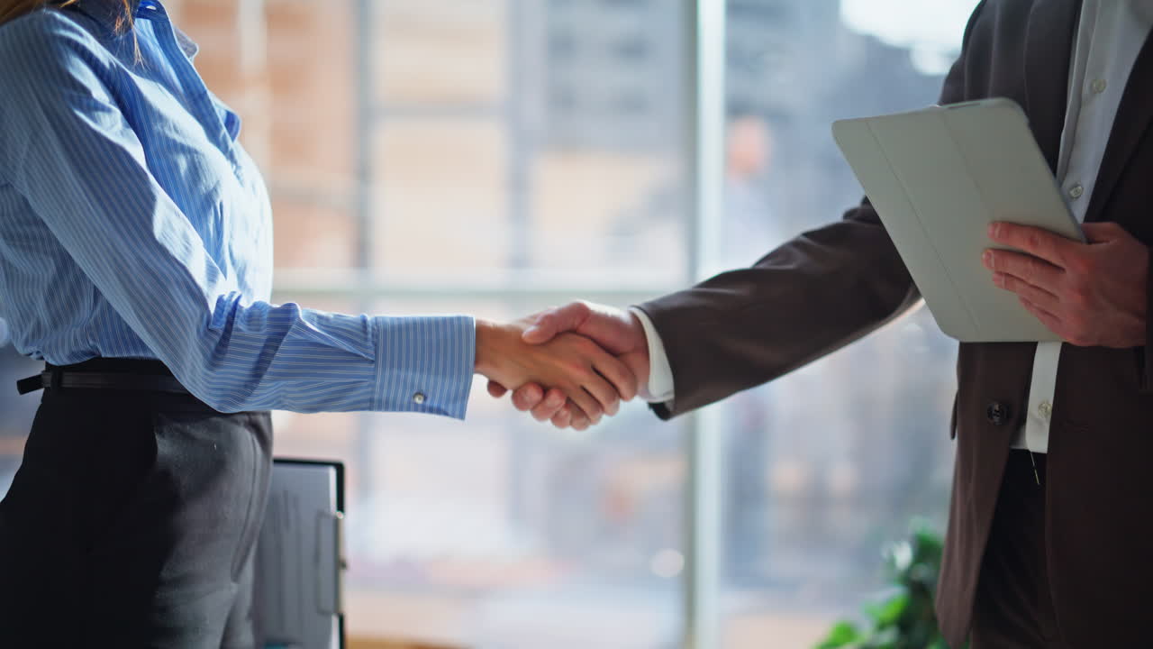 Primo piano di due colleghi che si stringono la mano in ufficio. Stretta di mano tra partner commerciali.