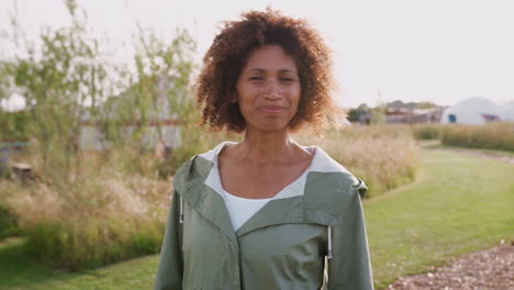 Retrato-De-Una-Mujer-Madura-Sonriente-Visitando-Un-Camping-De-Yurtas-En-El-Campo