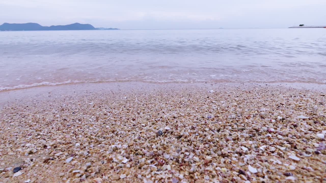 Explore the serene beauty of a pebbly shoreline meeting the tranquil sea embodying nature's calm.