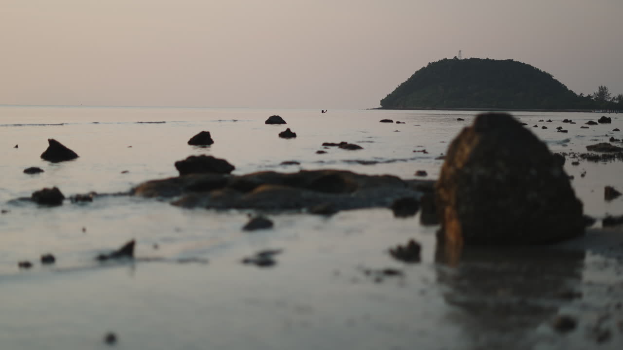 Tranquil Beach Scene with Island and Rocks at Dusk