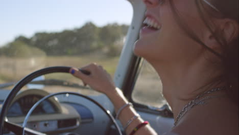 hermosa chica conduciendo un coche antiguo en un viaje por carretera