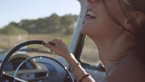 beautiful girl driving vintage car on road trip