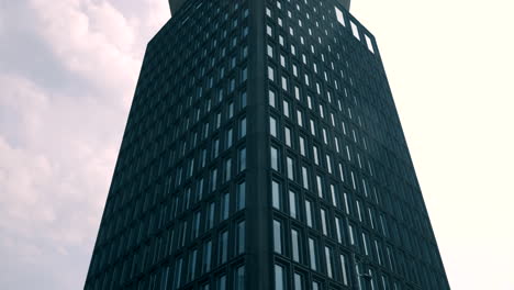 Time-lapse-of-a-symmetrical-office-building-with-a-cloudy-sky-moving-behind-it