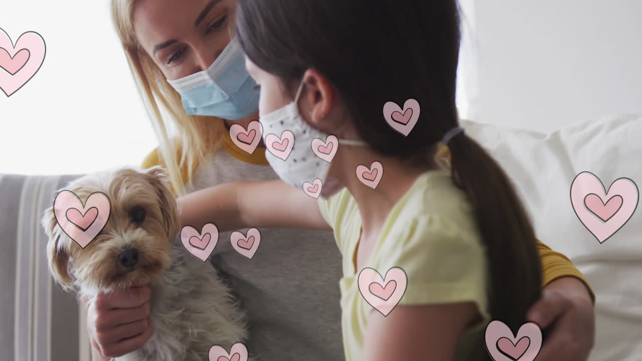 animación de corazones sobre mujer caucásica y su hija con máscaras faciales jugando con un perro mascota