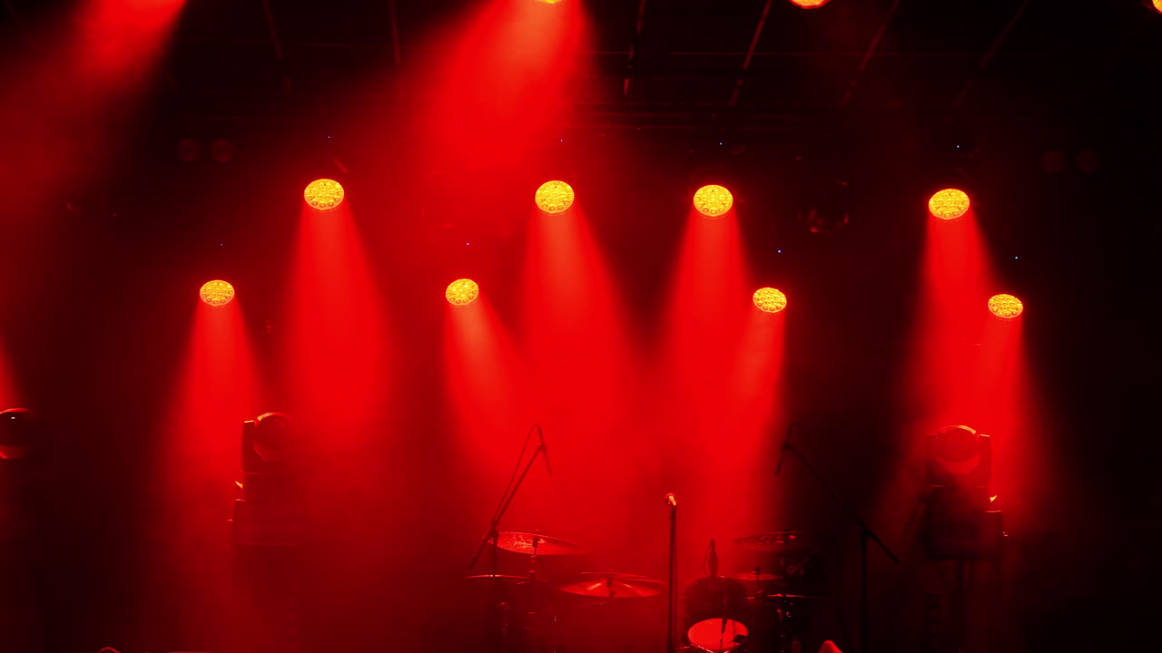 Red stage lights shining on dark concert stage
