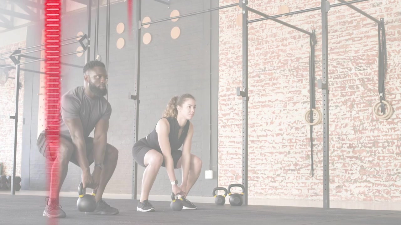 Partner di fitness che abbassano i fianchi e oscillano kettlebell in palestra, frecce rosse che tracciano le metriche di potenza