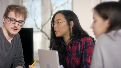 young confident asian business woman talking about business sheets to coworkers