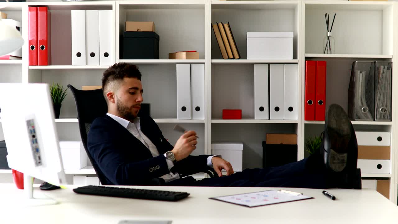 joven empresario trabajando con las piernas en la mesa en la oficina