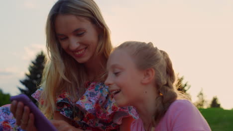 Cheerful-family-laughing-at-meadow.-Woman-and-girl-having-fun-in-city-park.