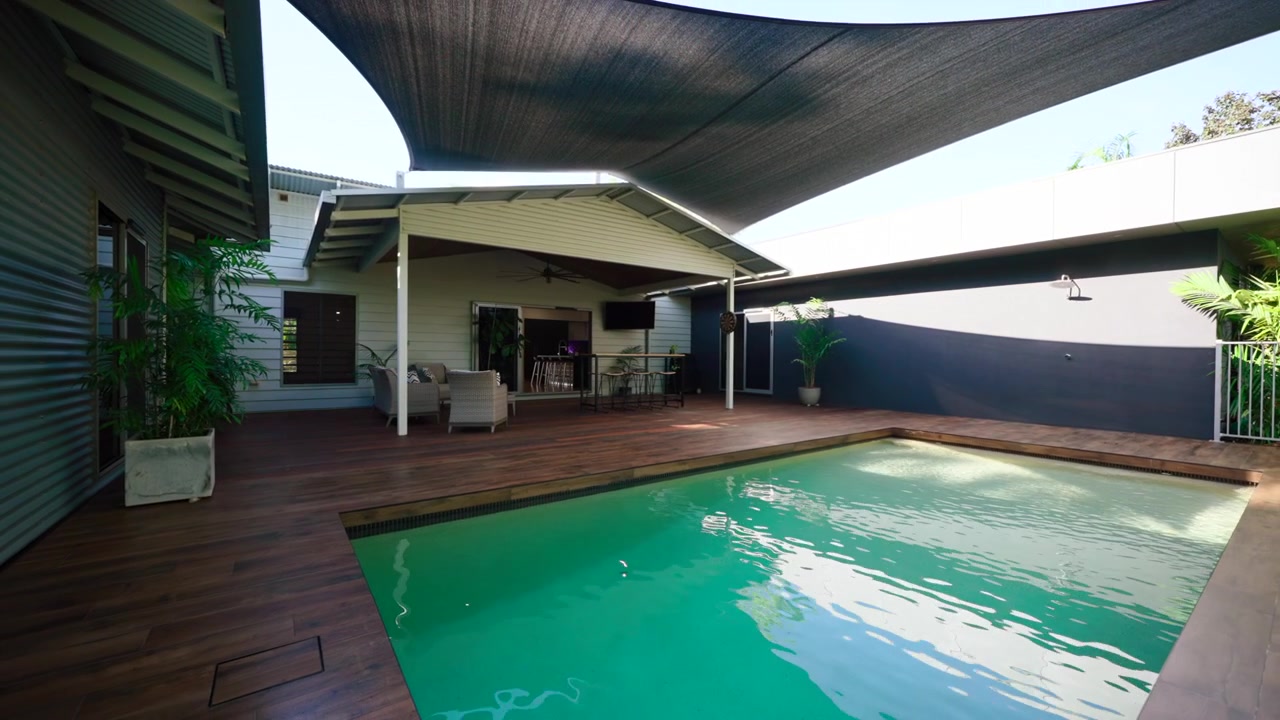 Rural Country Tropical Home Small Rectangular Pool With Cool Relaxing Water Surrounded by Stained Wooden Deck To Give Elegant Feel. Exterior of house for real estate property.