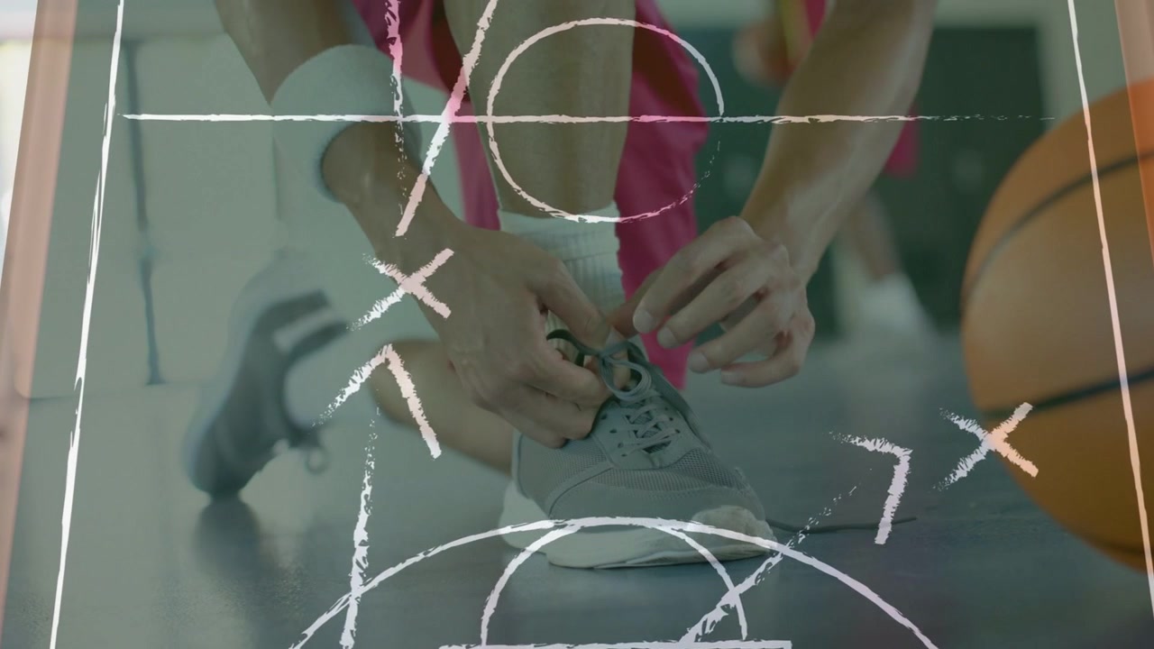 Male athlete tying shoe laces preparing for basketball game with chalk diagrams sliding over hands