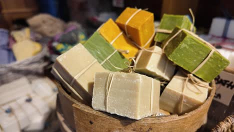 assorted handmade soaps in wooden bowl
