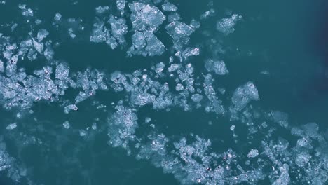 Aerial top down of icy ice floe flowing on river in Iceland. Global warming theme. Melting icebergs on river.
