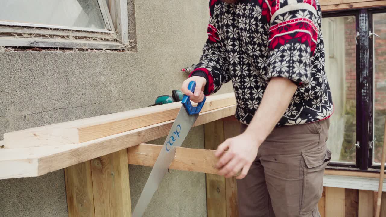 Man Using Hand Saw In Cutting Woods - Man Building A Greenhouse - Close Up