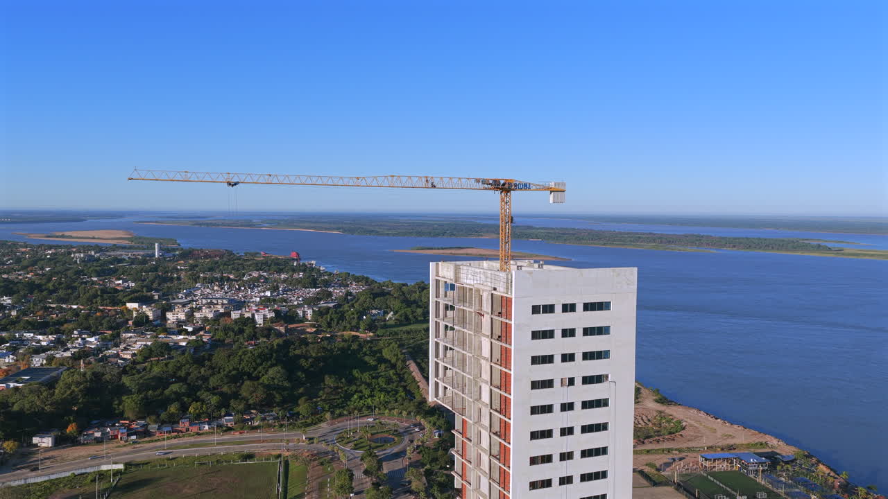 Aerial view of a white high-rise under construction with a crane in Corrientes, Argentina