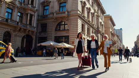 three women traveling through a european city with luggage and a map