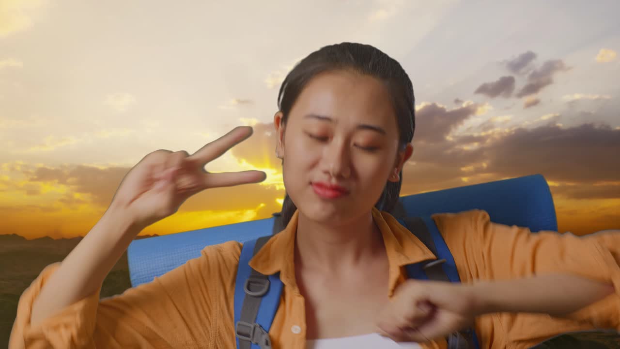 Close Up Of Asian Female Hiker With Mountaineering Backpack Enjoy Dancing On The Top Of Mountain During Sunset Time
