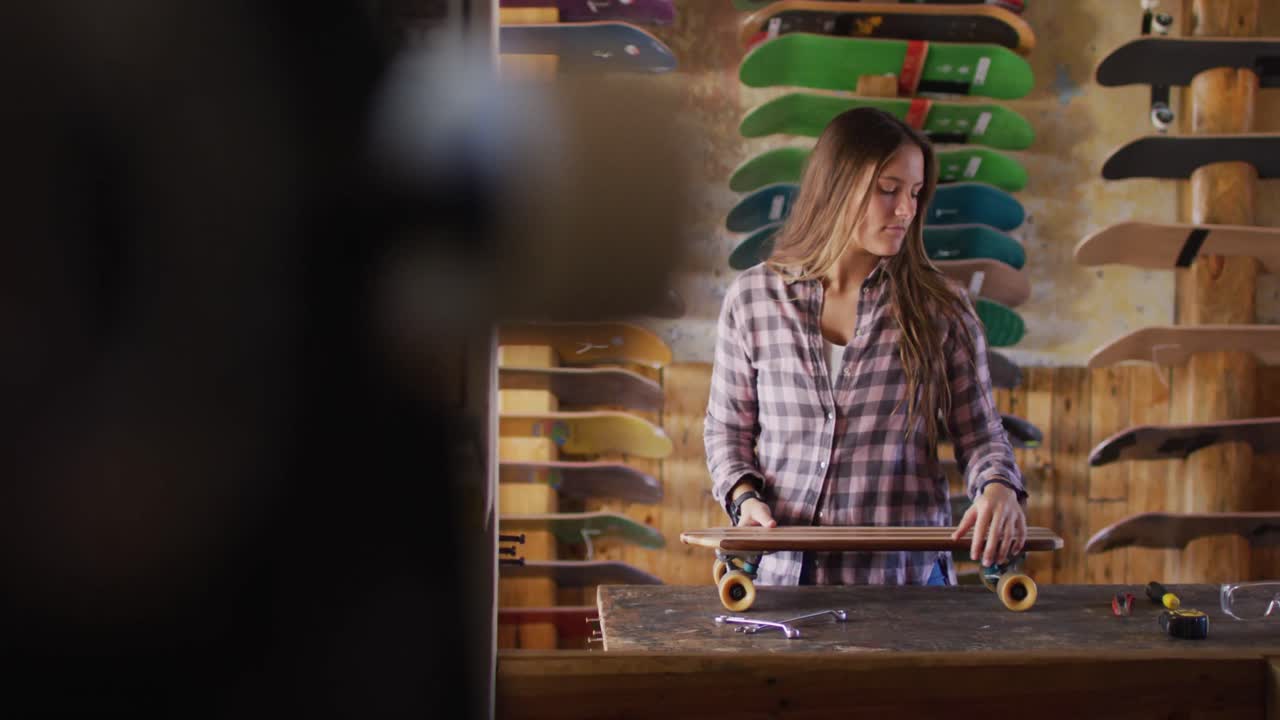 Video di una skateboarder donna caucasica felice in un negozio di skate.