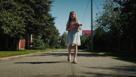 little girl walks outdoors in residential area on sunny day holding stuffed bunny, surrounded by shadows from trees and power lines, appearing thoughtful while dressed in light blue summer outfit