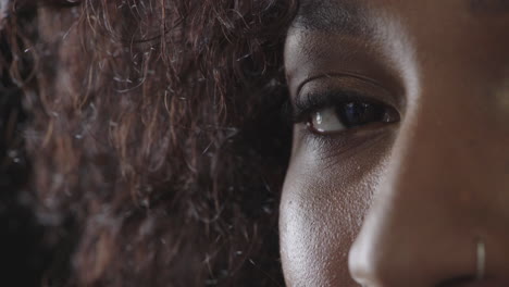 close-up-of-black-woman-eye-blinking-looking-serious-at-camera-wearing-nose-ring