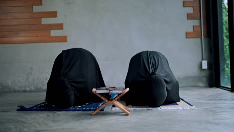 asian young muslim woman and sister praying at home