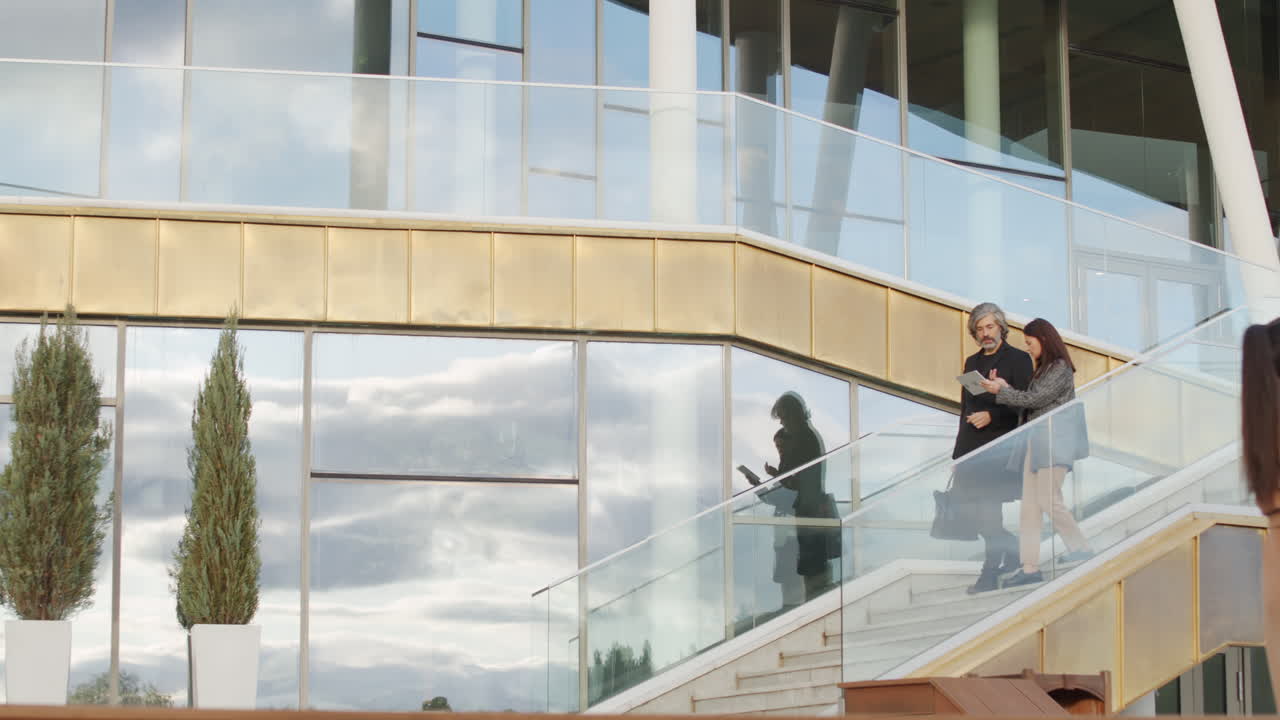 Business Professionals Walking and Discussing on Modern Office Building Stairs