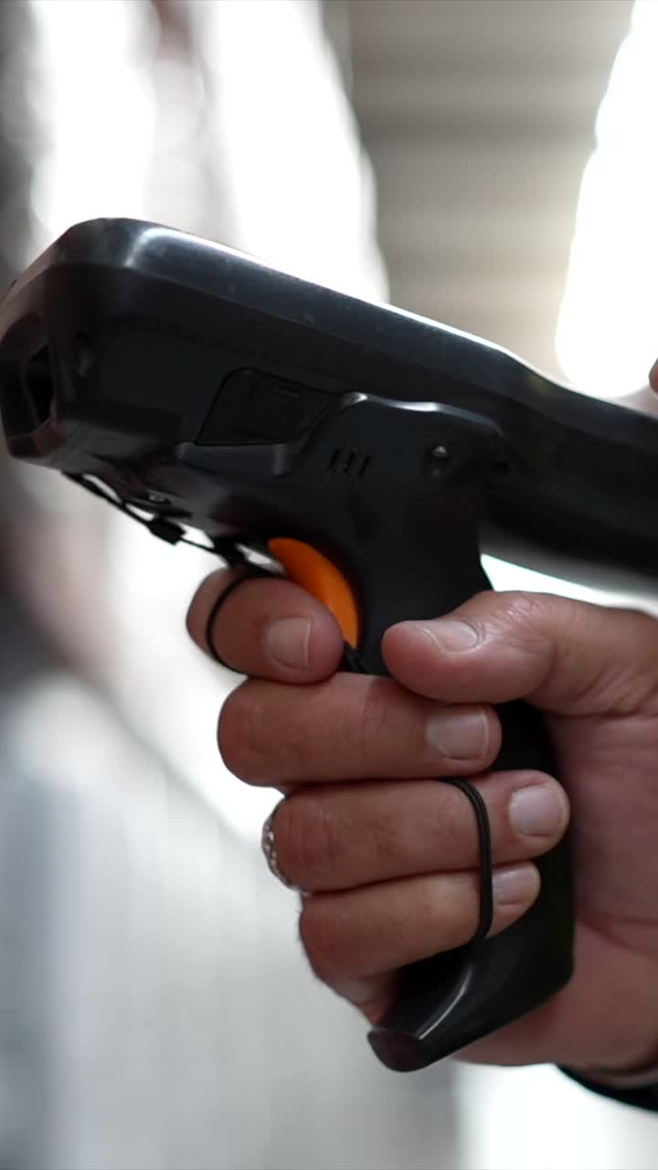 Close-up of a hand holding a barcode scanner