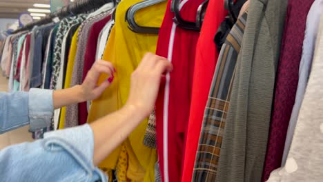 shopping for clothes coats and sweaters on a hanger in a store shopping for clothes coats and sweaters on a hanger in a store winter womens fashion clothes discounts in the store