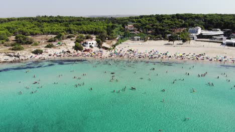 Un-Dron-Vuela-Hacia-Atrás-Desde-La-Playa-De-Lido-Silvana-Revelando-Los-Asombrosos-Colores-Del-Agua