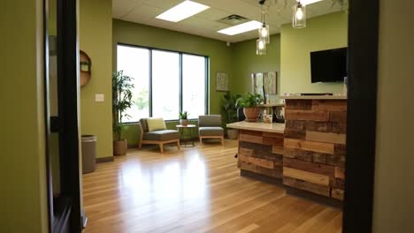 bright and inviting interior of a modern reception area featuring natural light, green walls, cozy seating, and elegant decor for relaxation and comfort