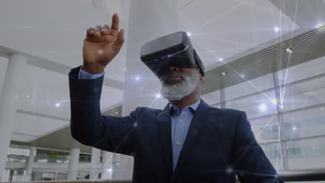 old man wearing a virtual reality headset while waving his fingers