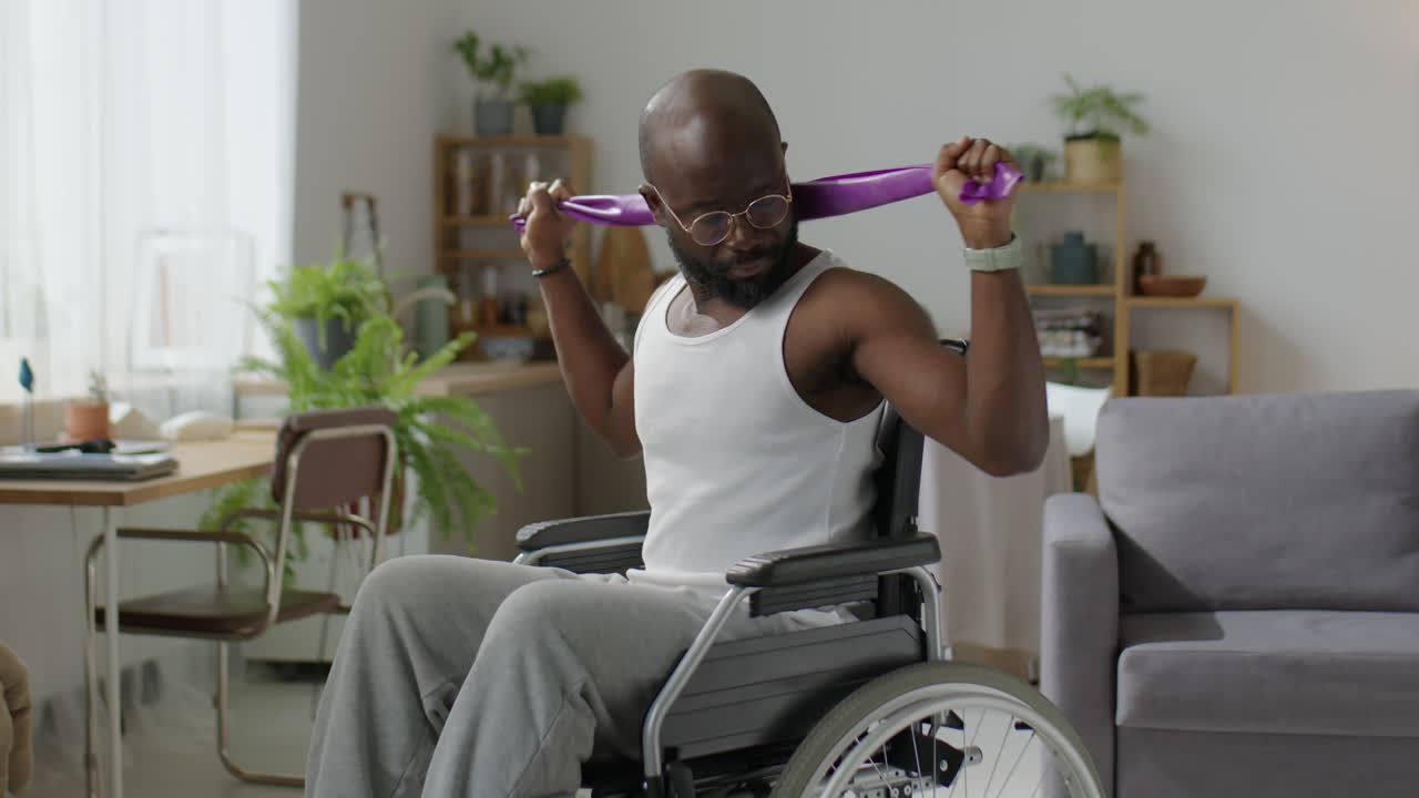 Man in Wheelchair Doing Home Workout with Resistance Band