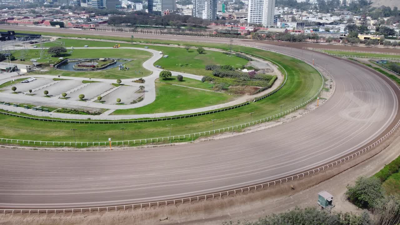 video de un dron orbitando alrededor de la curva de una pista de carreras de caballos