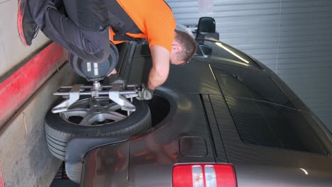 mechanic performing wheel alignment on a car