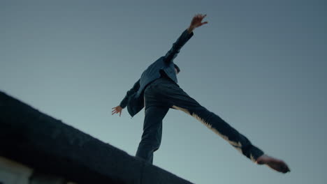 man dancing on roof of building, worms eye view, fisheye wide angle slow motion