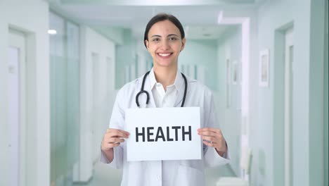 happy indian female doctor holding health banner