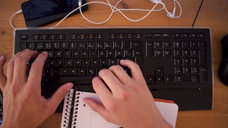 il giovane sta scrivendo un testo sul suo computer usando una tastiera-2
