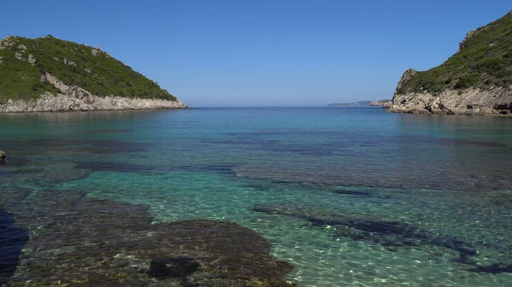 Ripresa panoramica fluida delle acque cristalline della spiaggia di Porto Timoni sull'isola di Corfù