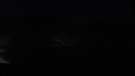 slow motion of a distant cloud at night with heady lightning happening inside it